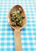 Small capers on a wooden spoon