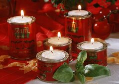 Tea lights in tins with basil and pasta as table decoration