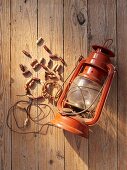 A necklace of wooden beads and an old oil lamp as props for a Western-themed party