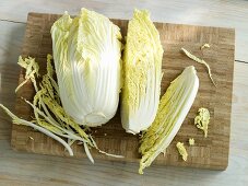 Chinese cabbage on a wooden board, whole and quartered