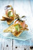 Salmon rolls with avocado on toast triangles