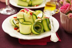 Zucchinistreifen mit Chili und Pinienkernen