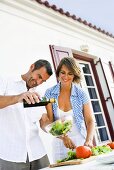 Couple preparing salad out of doors