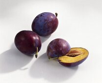 Two whole and one halved plum (variety: Top)