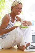 Woman with plate of salad and glass of milk