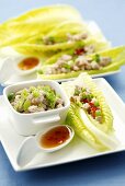 Pork with spring onions on lettuce leaves, chilli sauce