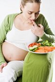 Pregnant woman with plate of vegetables