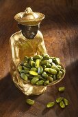 Gilded statuette with shelled pistachios