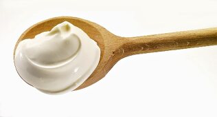 Sour cream on wooden spoon