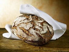 Crusty loaf in linen cloth