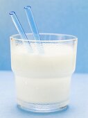 Glass of milk with blue straws