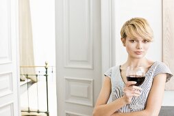 Junge Frau mit einem Glas Rotwein