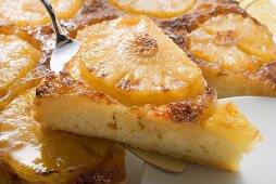 Pineapple upside-down cake, a piece on server (close-up)