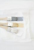 Paintbrushes with three different colours of paint on paper