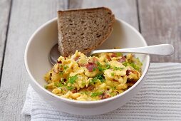 Scrambled egg with ham, parsley and bread