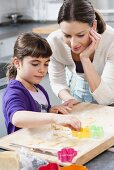 Mother and daughter baking biscuits