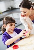 Mother and daughter cutting out biscuits