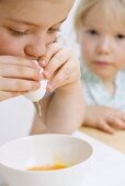 Child blowing a raw egg