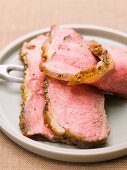 Slices of roast beef on plate with meat fork