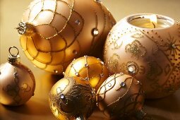 Champagne coloured Christmas baubles and a ball shaped candle holder