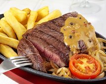 Rump steak with pepper sauce, onions and chips