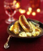 Sausage with gravy on a bed of mashed potatoes