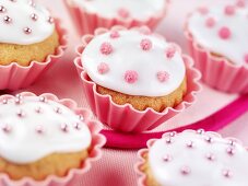 Cupcakes mit weisser Glasur und rosa Zuckerperlen