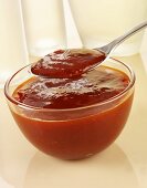 Barbecue sauce in glass bowl and on spoon