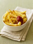 Pommes frites mit Ketchup in einem Schälchen