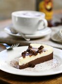 A slice of cheesecake with a cappuccino
