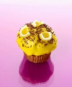 Muffin with yellow icing, chocolate vermicelli & jelly sweets