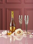 Bottle of champagne, chocolate truffles, roses and champagne glasses
