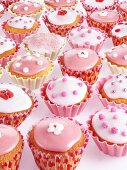 Lots of fairy cakes decorated in pink and white