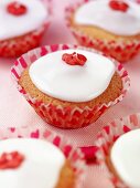 Cupcake mit weisser Glasur und roter Zuckerblume