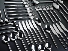 Knives, forks and spoons arranged in rows