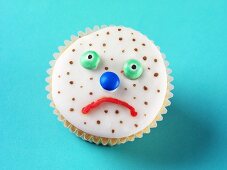 Fairy cake decorated with a sad, spotty face