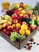 Fresh fruit and berries in a wooden crate