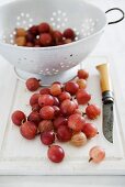 Gooseberries on a chopping board and in a colander