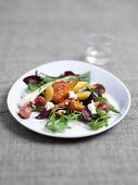 Fried beetroot, radishes and carrots with sheep's cheese on a bed of rocket