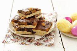 Blechkuchenstücke mit Karamell, Pflaumen, Mandeln & Schokolade