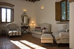 Light colored living room suite in a living room of a country home with a tile floor