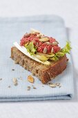 Wholemeal bread topped with chicory, beetroot paste, sunflower seeds and pumpkin seeds