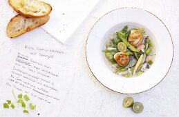 Clear vegetable soup with asparagus and scallops