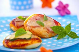 Mini pizzas with zucchini, cheese and basil