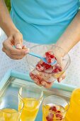 Putting berry ice cubes in juice glasses