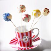 Cake pops with colorful sprinkles in a cup