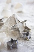 Star-shaped cutters on top of a pile of flour
