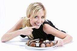A blonde woman eating a birthday cake