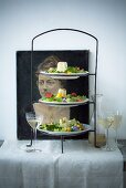 Mixed leaf salad with flowers and goat's cheese on a cake stand
