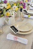 A place setting with a name card on a table set with spring flowers